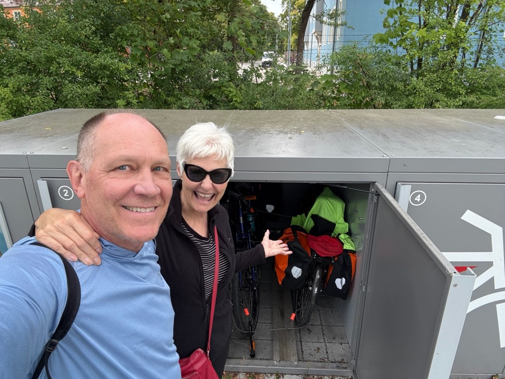 Man and woman standing next to open bicycle locker