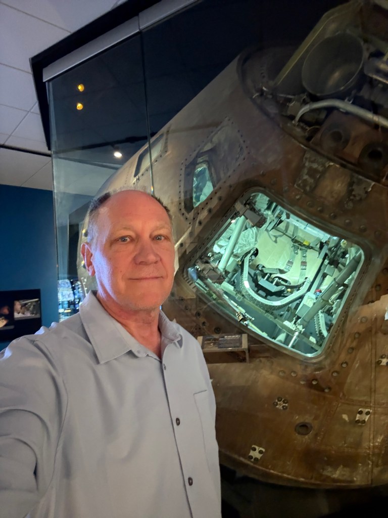 Standing in front of Apollo 13 command module